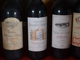 several bottles of red wine are lined up on a table