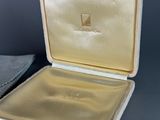 an open box with a gold lid sitting on top of a table