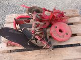 a red plow sitting on top of a wooden pallet