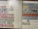 an open book with stamps on it on a table