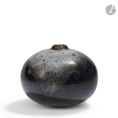a black and white vase sitting on a white surface