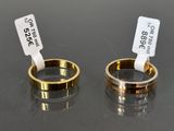two gold wedding rings with price tags on them sitting next to each other