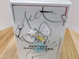 the box for the perfume is sitting on a wooden table