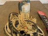 a rope and a bottle on a table next to a remote control