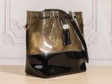 black and gold bucket bag with tassels on wooden table