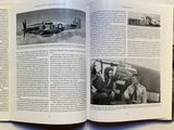 an open book with a black and white photo of a plane
