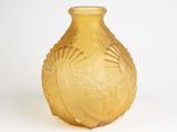 un vase jaune posé sur une surface blanche