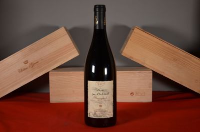 a bottle of wine sitting on a table next to two wooden boxes