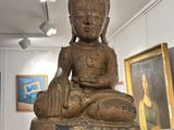 une statue de Bouddha assis sur une table en verre