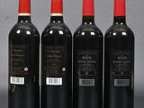 three bottles of red wine sitting next to each other on a table