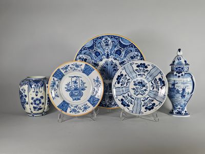 plusieurs assiettes et vases bleus et blancs exposés sur un fond gris