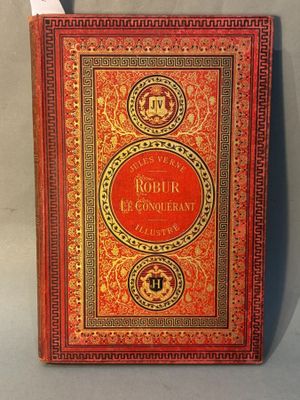 an old book with a red cover sitting on top of a table