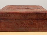 an old wooden box sitting on top of a table next to a wall