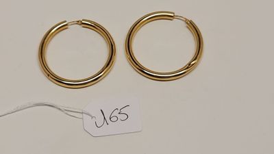 une paire de boucles d'oreilles en or sur fond blanc