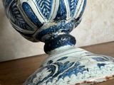 a blue and white vase sitting on a wooden table