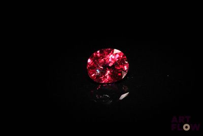 a close up of a red diamond on a black surface