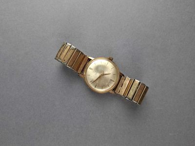 an image of a gold wrist watch on a gray surface