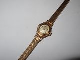 an image of a gold wrist watch on a white surface