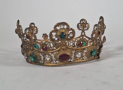 couronne en or ornée de bijoux et de pierres précieuses, posée sur un fond blanc
