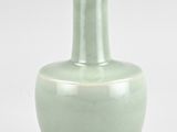 a green vase that is sitting on a white surface