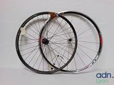 une paire de roues de vélo noires et blanches posées sur une surface blanche