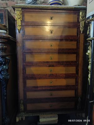 une commode dans une pièce, sur laquelle est posé un vase