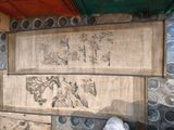 une personne debout près d'un mur sur lequel sont accrochés plusieurs tableaux