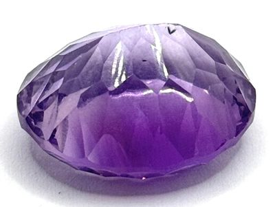 gros plan d'une pierre précieuse violette sur une surface blanche