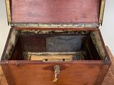 une vieille boîte en bois posée sur une table, avec une clé à l'intérieur