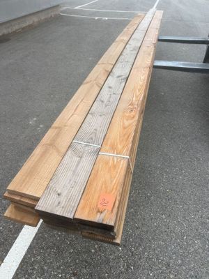 un long banc en bois posé au milieu d'un parking