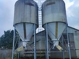deux silos situés sur le côté d'un bâtiment, avec le ciel en arrière-plan