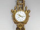 une horloge en or accrochée au mur d'une pièce