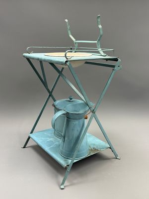 une petite table sur laquelle se trouvent une théière et un arrosoir