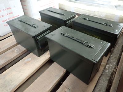 trois caisses métalliques posées les unes à côté des autres sur une palette