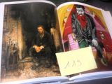 un livre ouvert sur lequel figure l'image d'un homme assis sur une chaise