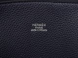 a close up of a black leather purse with a logo on it