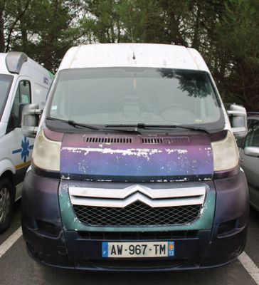 purple and blue van parked in a parking lot next to other cars