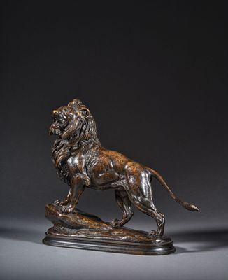une statue en bronze représentant un lion, posée sur un socle en bois
