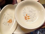two plates with orange flowers on them sitting on a table