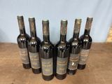 six bottles of wine sitting on top of a wooden table
