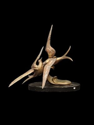 sculpture en bronze représentant deux oiseaux sur fond noir