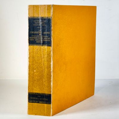 an old book sitting on top of a white table next to a white wall