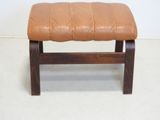 a small bench with a brown leather seat on it