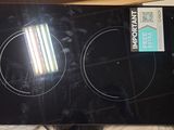 a black stove top with two burners on top of it