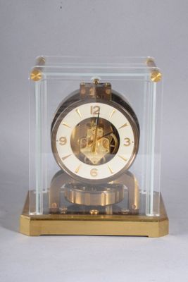 a clock that is in a glass case on a table