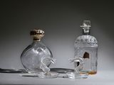 a glass bottle with a horse on it next to a glass bottle with a horse on it