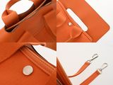 an orange purse with a metal handle and a metal clasp