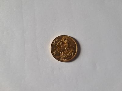 a gold coin on a white surface with a white background