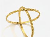 gros plan d'une bague en or sur une surface blanche