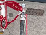 a red bike parked in front of a garage door